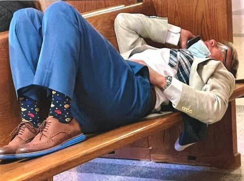 Personal injury trial attorney John Griffith lying on court bench after trial