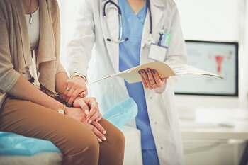 Woman meeting with doctor discussing pain of injuries