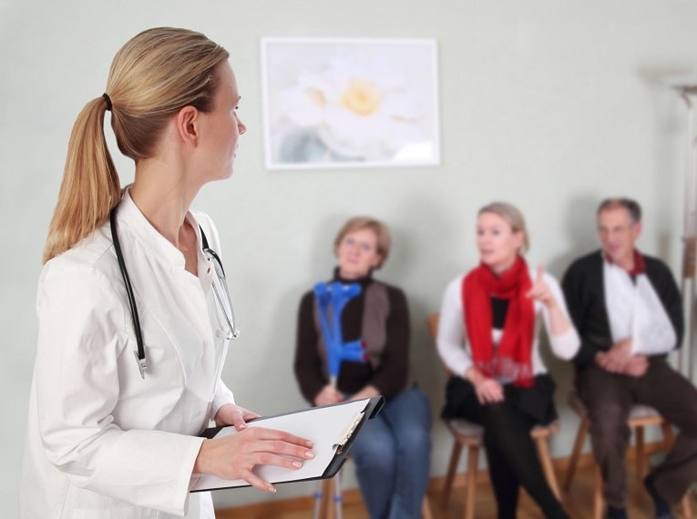 Female doctor holding clipboard in doctors office