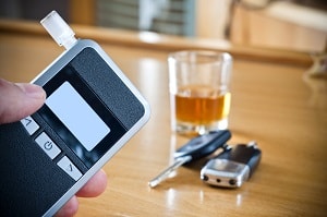 Breathalizer with drink and keys behind it