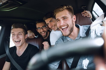 Group of friends riding in car as passengers