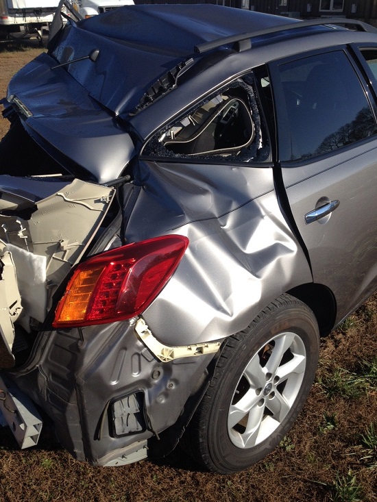 Totaled SUV with significant damage to back of car from being hit by truck