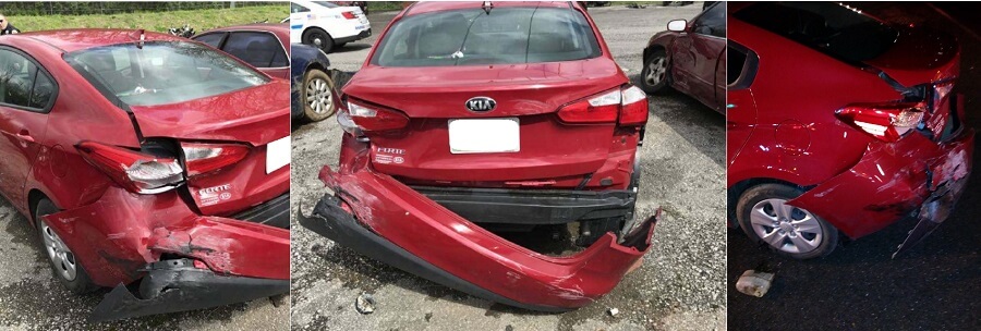Wrecked red Kia with significant damage to the rear