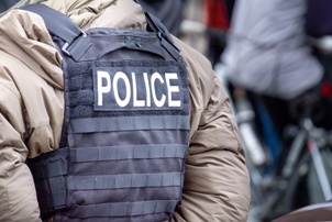 back of police officer in coat and vest