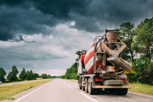 cement mixer truck driving down road