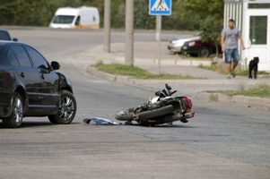 damaged motorcycle in street after car accident