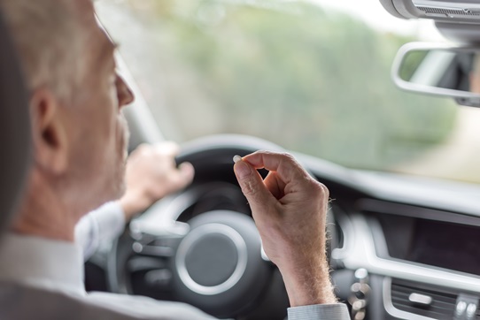driver taking a pill behind the wheel impaired driving
