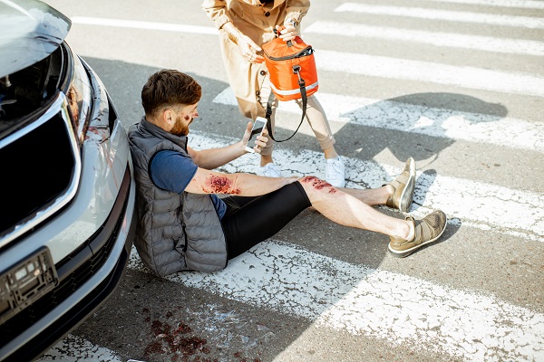injured pedestrian receiving care after being hit by a car