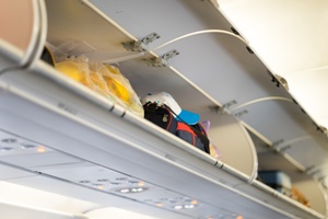 open overhead luggage bin on airplane