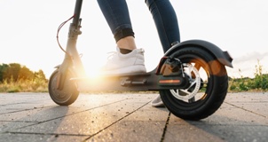 person riding electric scooter on pavement