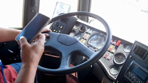 semi truck driving using cell phone at the wheel