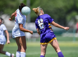 adolescent girls heading soccer ball