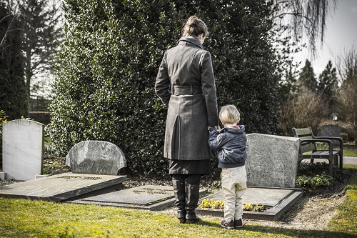 Grieving wife and boy at grave site of family member killed in a wrongful death accident