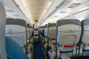 airplane aisle and flight attendant with cart