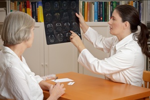 doctor showing older woman MRI brain scans