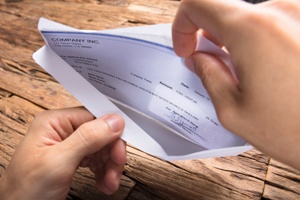 hands opening insurance settlement check