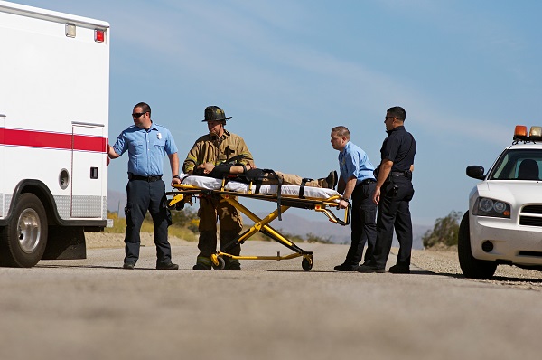 injured law enforcement officer on stretcher going into ambulance