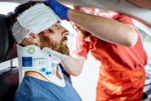 man with head and neck injuries being treated after car accident