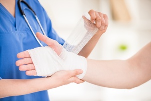 nurse bandaging a patient's hand and wrist