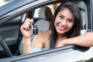 happy teen driver in car showing car keys