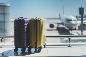 suitcases in airport with airplane in background