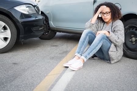 woman holding head after car accident